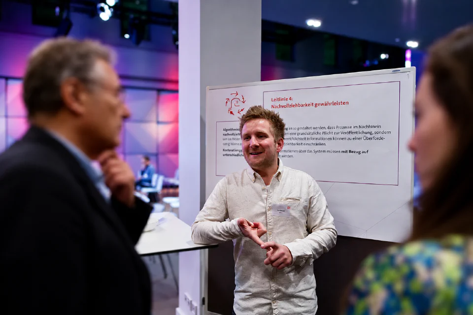 Gespräch vor einem Flipchart mit der Überschrift: Nachvollziehbarkeit gewährleisten.